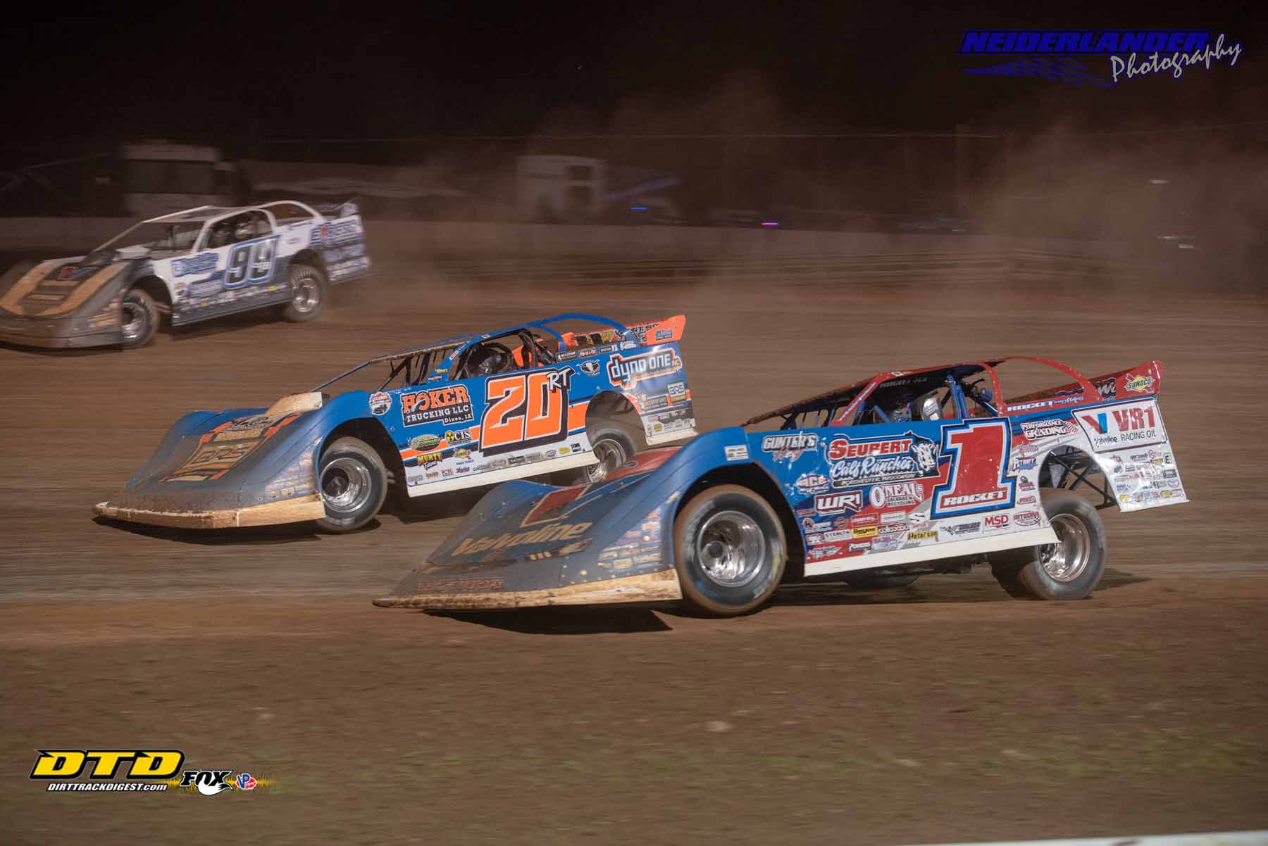 Dirt Late Models racing each other 3 wide
